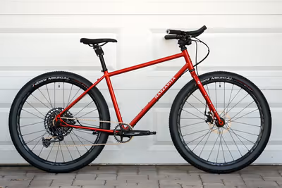 Red steel bikepacking bike with steel fork