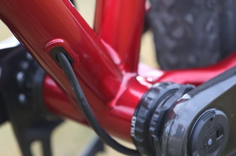 The rear brake hose exits the down tube and routes externally to the caliper along the chainstay